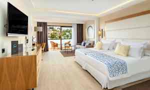 Hotellihuone, jossa kaksi sänkyä, istuinryhmä ja parveke. (Tekoälyn luoma teksti)