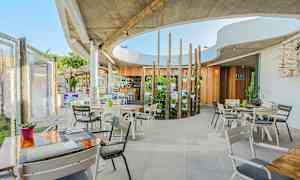 Moderni ulkoilmaravintola, jossa on puu- ja betoniyksityiskohtia. (Tekoälyn luoma teksti)