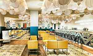 Moderni ja kutsuva ravintola keltaisilla nojatuoleilla, koristeellisilla lyhdyillä katossa ja tyylikkäällä baarilla. (Tekoälyn luoma teksti)