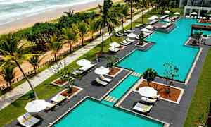 Uima-allasalue rannalla, jossa on aurinkotuoleja ja aurinkovarjoja. (Tekoälyn luoma teksti)