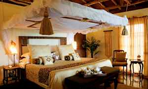 Houkutteleva sänky, jossa on katos ja vaaleat tekstiilit, rustiikkisesti sisustetussa huoneessa. (Tekoälyn luoma teksti)