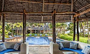 Näkymä katetulta istuinalueelta, jossa on sinisiä sohvia, altaalle ja ympäröivään vehreyteen. (Tekoälyn luoma teksti)