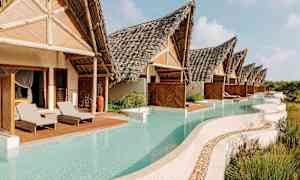 Kuvassa on rivi huviloita, joissa on olkikatot ja joiden edessä on yksityiset altaat, joita ympäröi kasvillisuus. (Tekoälyn luoma teksti)