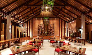 Tyylikäs ravintola, jossa on puukalusteita ja lämmin valaistus. Tuoleissa on punaiset pehmusteet, ja seinillä on koristelua sekä riippuvia valaisimia ja vihreitä kasveja. (Tekoälyn luoma teksti)