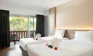 Hotellihuone, jossa on kaksi sänkyä koristeltuna pyyhe-eläimillä, jotka muistuttavat pieniä norsuja. (Tekoälyn luoma teksti)