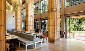 Valoisa ravintolaalue, jossa on suuria ikkunoita ja koristellut pylväät. (Tekoälyn luoma teksti)