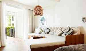 Olohuone, jossa on kulmasohva, tyynyjä ja lasiovet, jotka johtavat ulkoterassille. (Tekoälyn luoma teksti)