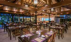 Avoin ravintola, jossa puiset pöydät ja tuolit, katetut aterioille. (Tekoälyn luoma teksti)