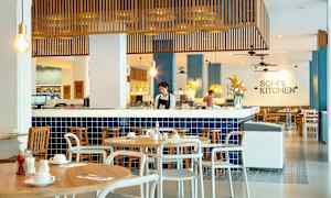 Kuva ravintolasta, jossa on moderni sisustus ja siniset kaakelit, ja puupöydät sekä tuolit on järjestetty ympäriinsä. (Tekoälyn luoma teksti)