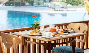 Aamiainen tarjoiltuna pöydässä uima-altaan lähellä. (Tekoälyn luoma teksti)
