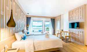 Hotellihuone kahdella vuoteella, merinäköala ja nykyaikainen sisustus. (Tekoälyn luoma teksti)