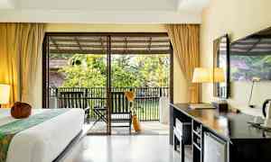 Hotellihuone, jossa on sänky, kirjoituspöytä ja parveke puutarhanäkymällä. (Tekoälyn luoma teksti)