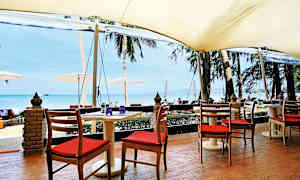 Istumapaikat pöydän ääressä katoksen alla, näkymä rannalle ja merelle. (Tekoälyn luoma teksti)