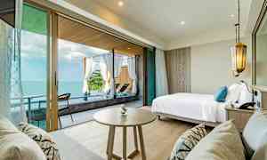 Huone merinäköalalla, sänky, pöytä sekä sohva ja terassi aurinkotuoleilla. (Tekoälyn luoma teksti)