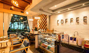 Tyylikäs kahvila, jossa on moderni sisustus, suuret ikkunat ja näkyvä kahvilatisk. (Tekoälyn luoma teksti)