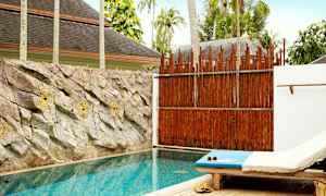 Yksityinen uima-allas, vieressä aurinkotuoli ja seinää koristavat kivet uima-altaan takana. (Tekoälyn luoma teksti)