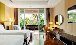 Nykyaikainen hotellihuone, jossa kaksi yhden hengen vuodetta, työpöytä, peili ja parveke vihreällä näkymällä. (Tekoälyn luoma teksti)