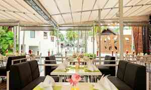 Ulkoruokailutila, jossa pöydät ja tuolit katettu katoksen alla. (Tekoälyn luoma teksti)