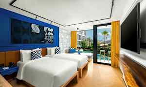 Moderni hotellihuone, jossa on kaksi erillistä vuodetta, sinisiä ja keltaisia sisustuselementtejä sekä lasiovi, joka johtaa pienelle terassille ja allasalueelle. (Tekoälyn luoma teksti)