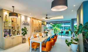 Kuva modernista kahvilasta, jossa on oransseja tuoleja ja vihreää sisustusta. (Tekoälyn luoma teksti)