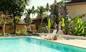 Ulkouima-allas, jota ympäröivät trooppiset puut ja koristeellinen kivipatsas. (Tekoälyn luoma teksti)