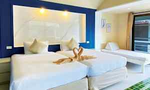 Kuva hotellihuoneesta, jossa on kaksi yhden hengen vuodetta, koristeellinen pyyhesydän ja päiväsänky vieressä. (Tekoälyn luoma teksti)