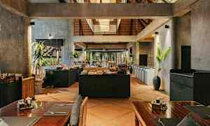 Ravintolan sisätiloja, joissa on rustiikkinen sisustus, puupöytiä ja buffetpöytä keskellä. (Tekoälyn luoma teksti)