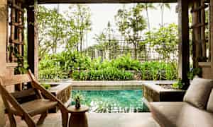 Avoin olohuone puutuoleilla ja -pöydällä, sohvalla sekä näkymä puutarhaan ja pieneen altaaseen. (Tekoälyn luoma teksti)