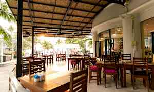 Ulkoravintola, jossa on katto ja terassilla sijaitsevia puupöytiä. (Tekoälyn luoma teksti)