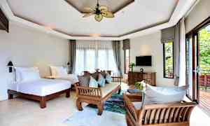 Valoisa ja tilava hotellihuone, jossa on kaksi erillistä vuodetta, puukalusteet ja suuret ikkunat, jotka avautuvat vehreälle parvekkeelle. (Tekoälyn luoma teksti)