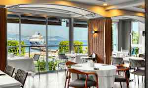 Ravintola, josta on näkymä satamassa olevaan risteilyalukseen. (Tekoälyn luoma teksti)