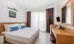 Hotellihuone, jossa on parivuode, kirjoituspöytä ja parveke. (Tekoälyn luoma teksti)