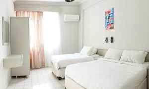 Valkoinen hotellihuone, jossa on kaksi vuodetta, ikkuna verhoilla ja vaatekaappi. (Tekoälyn luoma teksti)