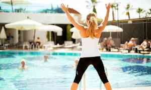 Henkilö seisoo uima-altaan edessä ja pitää käsiään ylhäällä. (Tekoälyn luoma teksti)