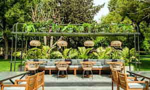 Ulkotila, jossa istumatilat, sohvat, tuolit ja vihreä ympäristö. (Tekoälyn luoma teksti)