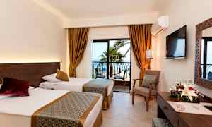 Hotellihuone, jossa kaksi erillistä vuodetta ja ikkuna näkymällä palmuihin ja merelle. (Tekoälyn luoma teksti)