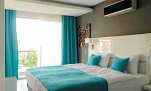 Moderni hotellihuone, jossa on parivuode, valkoisia ja turkooseja värejä. (Tekoälyn luoma teksti)