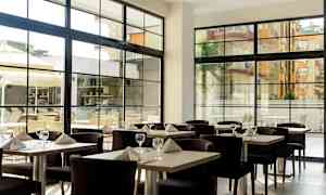 Ravintola katetuilla pöydillä ja suuret ikkunat. (Tekoälyn luoma teksti)