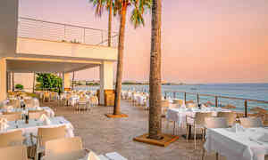 Ulkoravintola, josta on merinäköala auringonlaskun aikaan. (Tekoälyn luoma teksti)