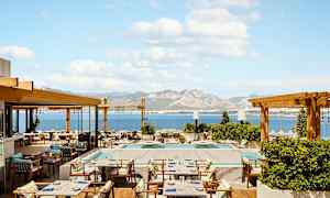 Ravintolaterassi, jolta on merinäkymä ja vuoria taustalla. (Tekoälyn luoma teksti)