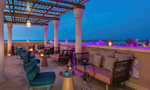 Katettu terassi, jossa istuimia ja valaistus merinäköalalla illalla. (Tekoälyn luoma teksti)