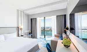 Hotellihuone, jossa on parivuode ja merinäköala suurista ikkunoista. (Tekoälyn luoma teksti)