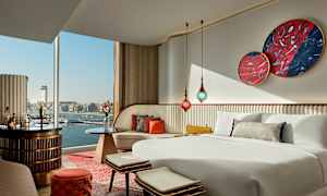 Makuuhuone, jossa on moderni sisustus ja näkymä satamaan ikkunan läpi. (Tekoälyn luoma teksti)