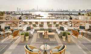 Ulkoilmaterassi, jossa on kalusteet ja näkymät satamaan ja kaupungin siluettiin taustalla. (Tekoälyn luoma teksti)