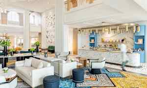 Tyylikäs hotellin aula, jossa on modernit huonekalut ja marmoritiski. (Tekoälyn luoma teksti)