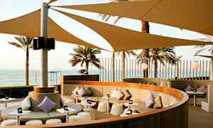 Istuma-alue varjoineen ja näkymä merelle. (Tekoälyn luoma teksti)