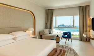 Hotellihuone, josta on näkymä merelle ja maailmanpyörälle. (Tekoälyn luoma teksti)