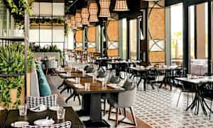 Modernin ravintolan sisätila, jossa on pöytiä, tuoleja ja koristeita. (Tekoälyn luoma teksti)