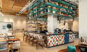 Moderni kahvila- ja baarisisustus värikkäillä huonekaluilla ja koristeilla. (Tekoälyn luoma teksti)