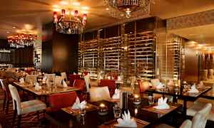 Tyylikäs ravintola, jossa on katettuja pöytiä, pehmustettuja tuoleja ja kattokruunuja katossa. (Tekoälyn luoma teksti)